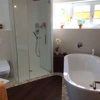 Badezimmer mit Duschkabine und Wanne mit Massagedüsen